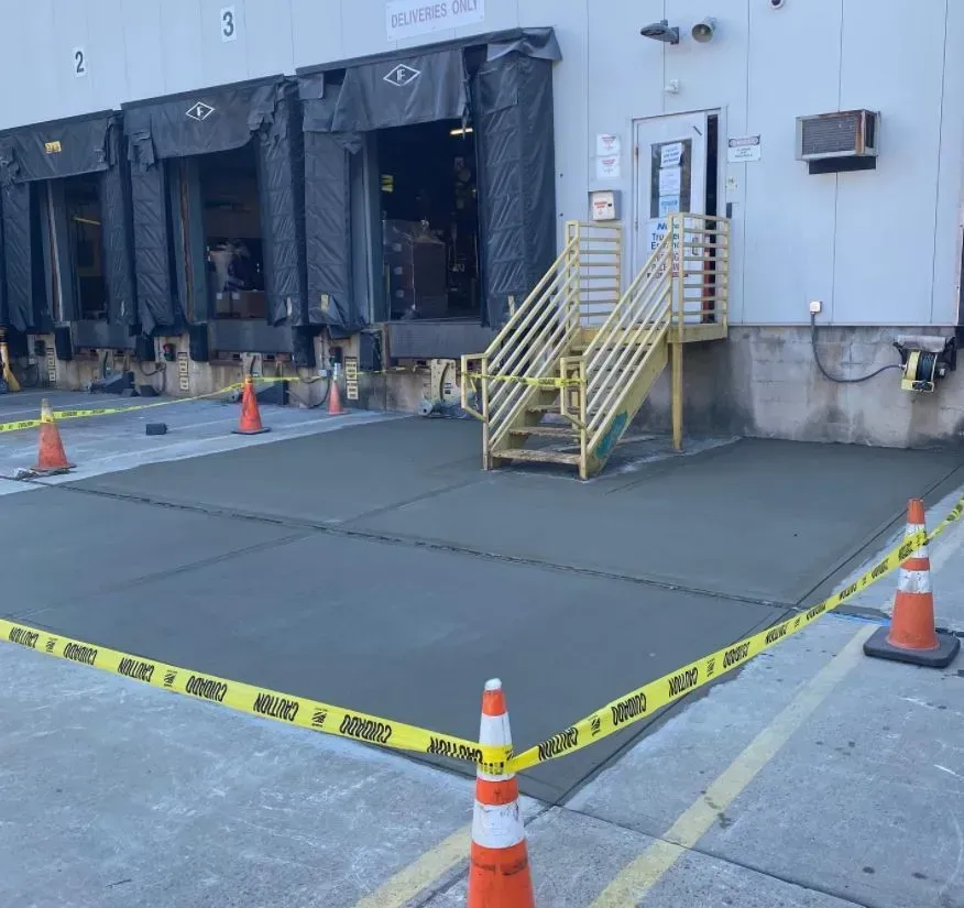 A loading dock with a yellow railing and stairs