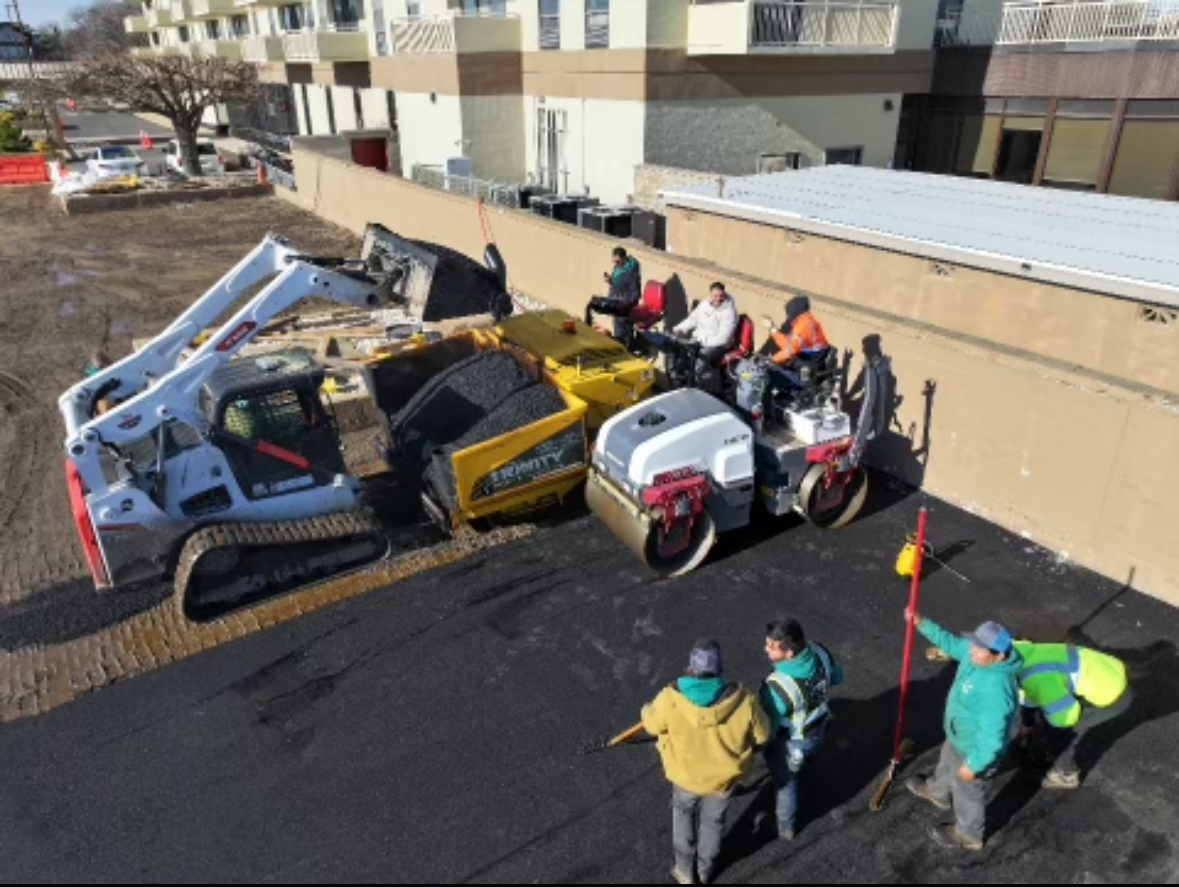 A group of construction workers are working on a road