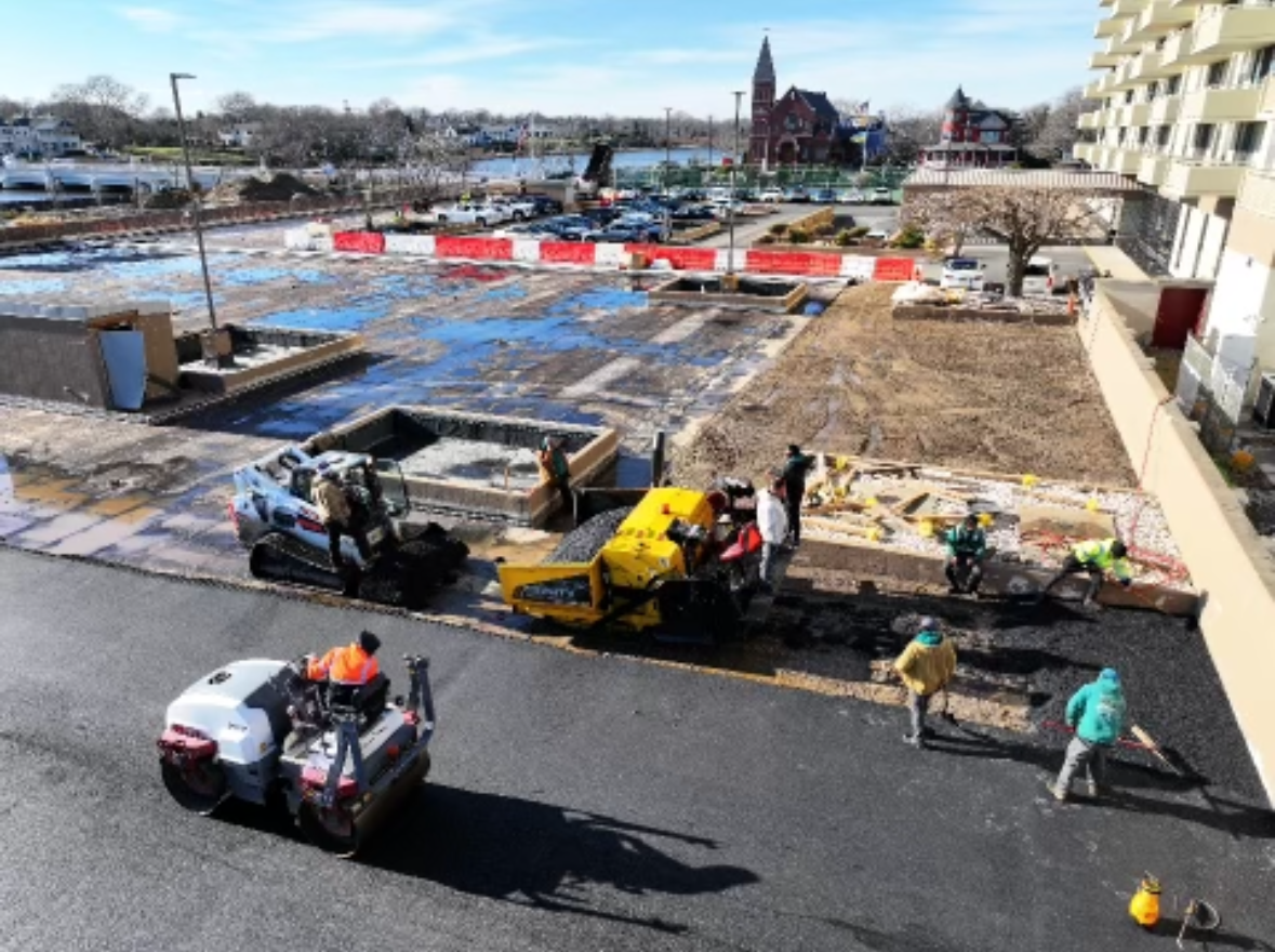 A group of construction workers are working on a road.