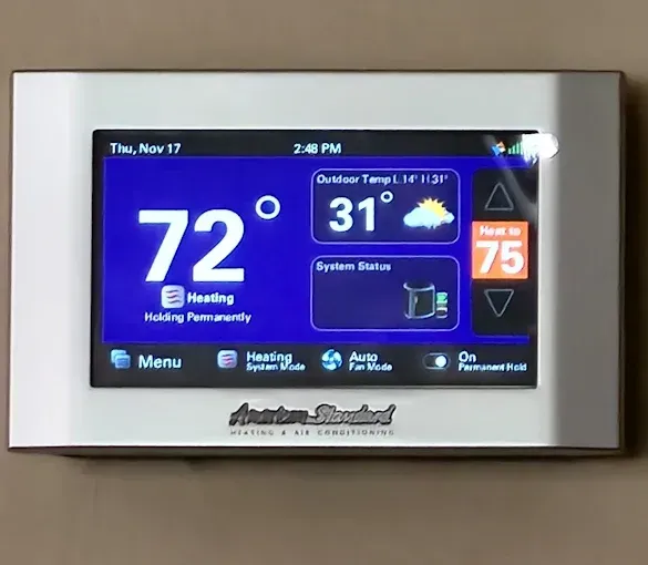 Smart thermostat showing 72 degrees, outdoor temp 31, heating system on.  American Standard brand.