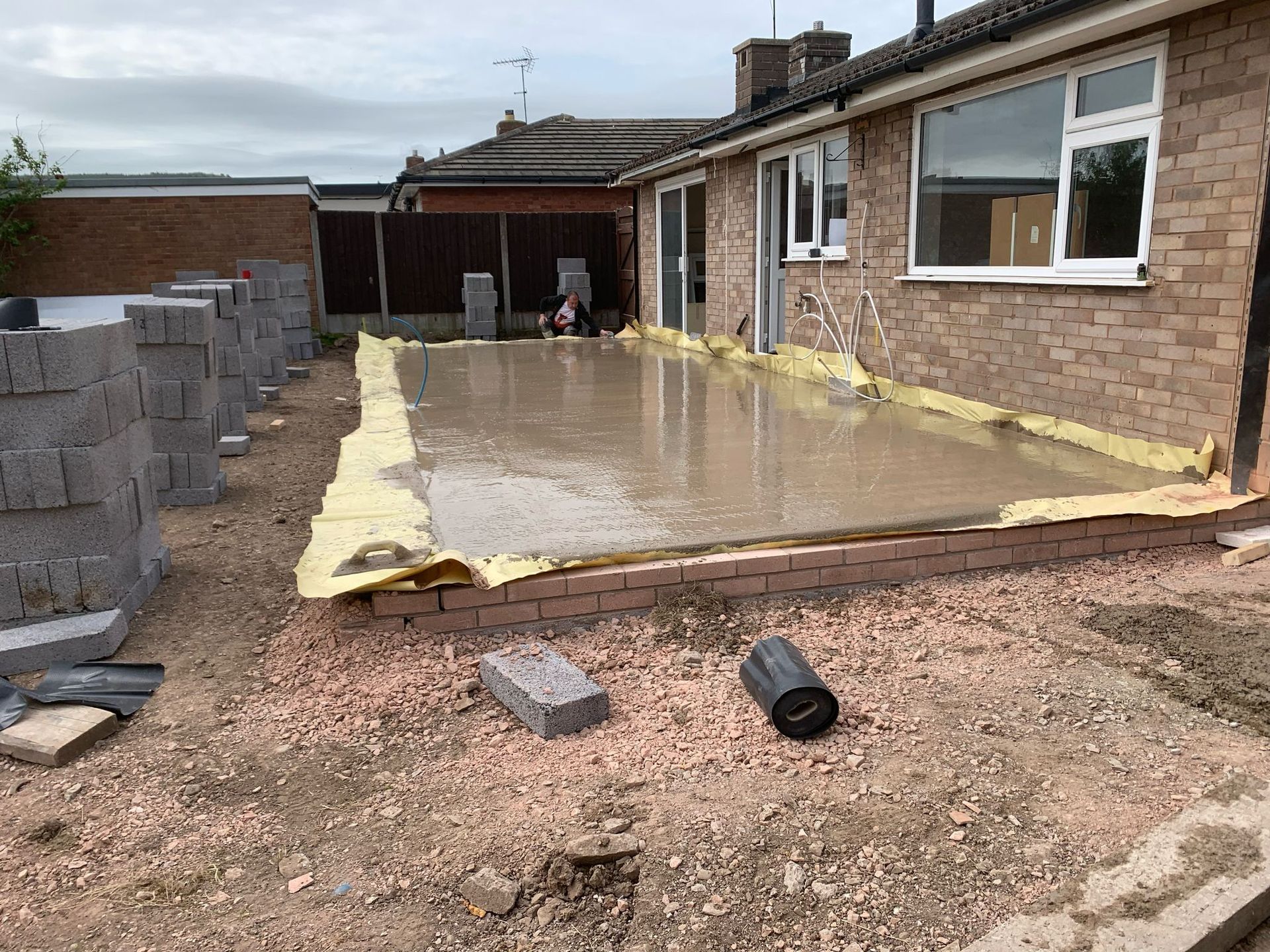 A brick house with a concrete patio in front of it.