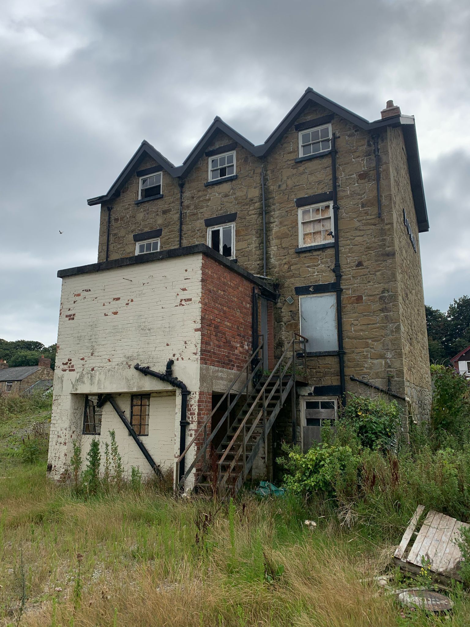 A large brick building is sitting in the middle of a field.