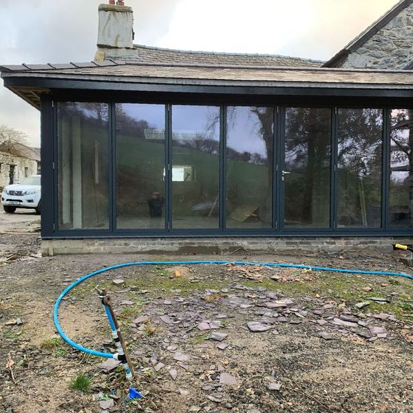A house with a lot of windows and a hose in front of it.