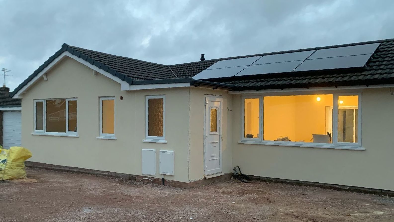 A house with a lot of windows and solar panels on the roof