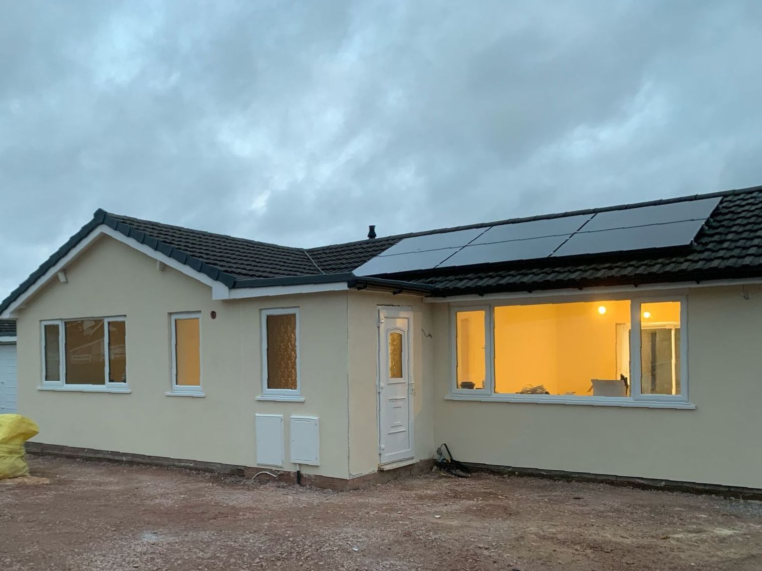 A house with a lot of windows and solar panels on the roof.