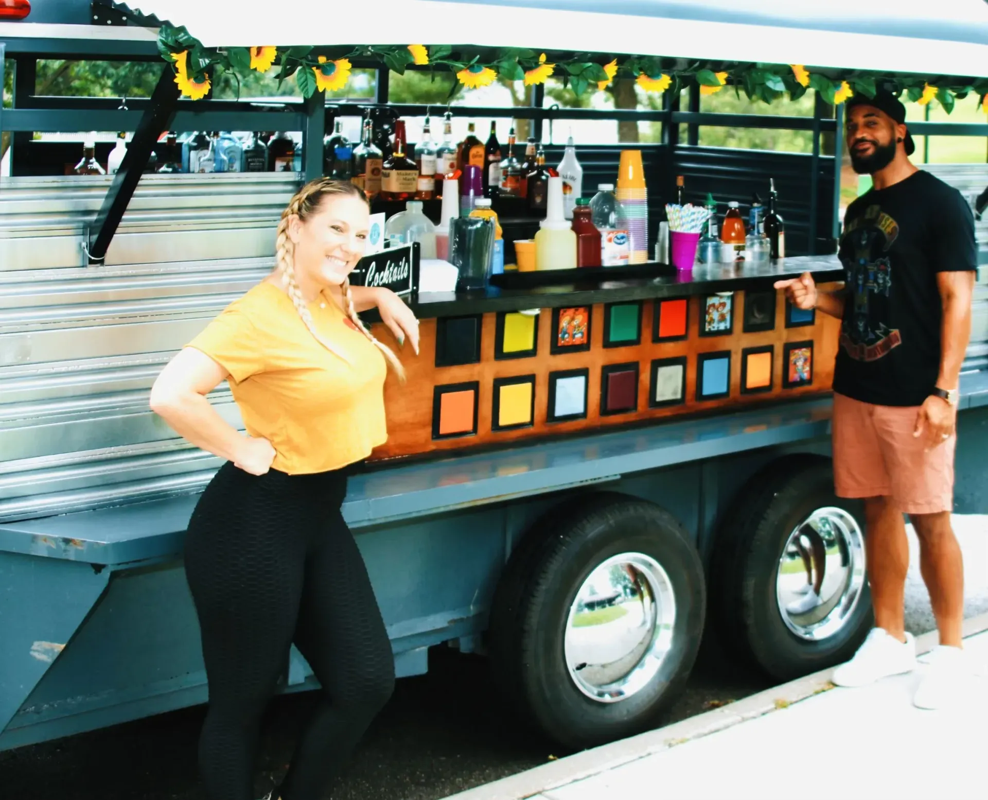 A man and a woman are standing next to a trailer with a bar on it