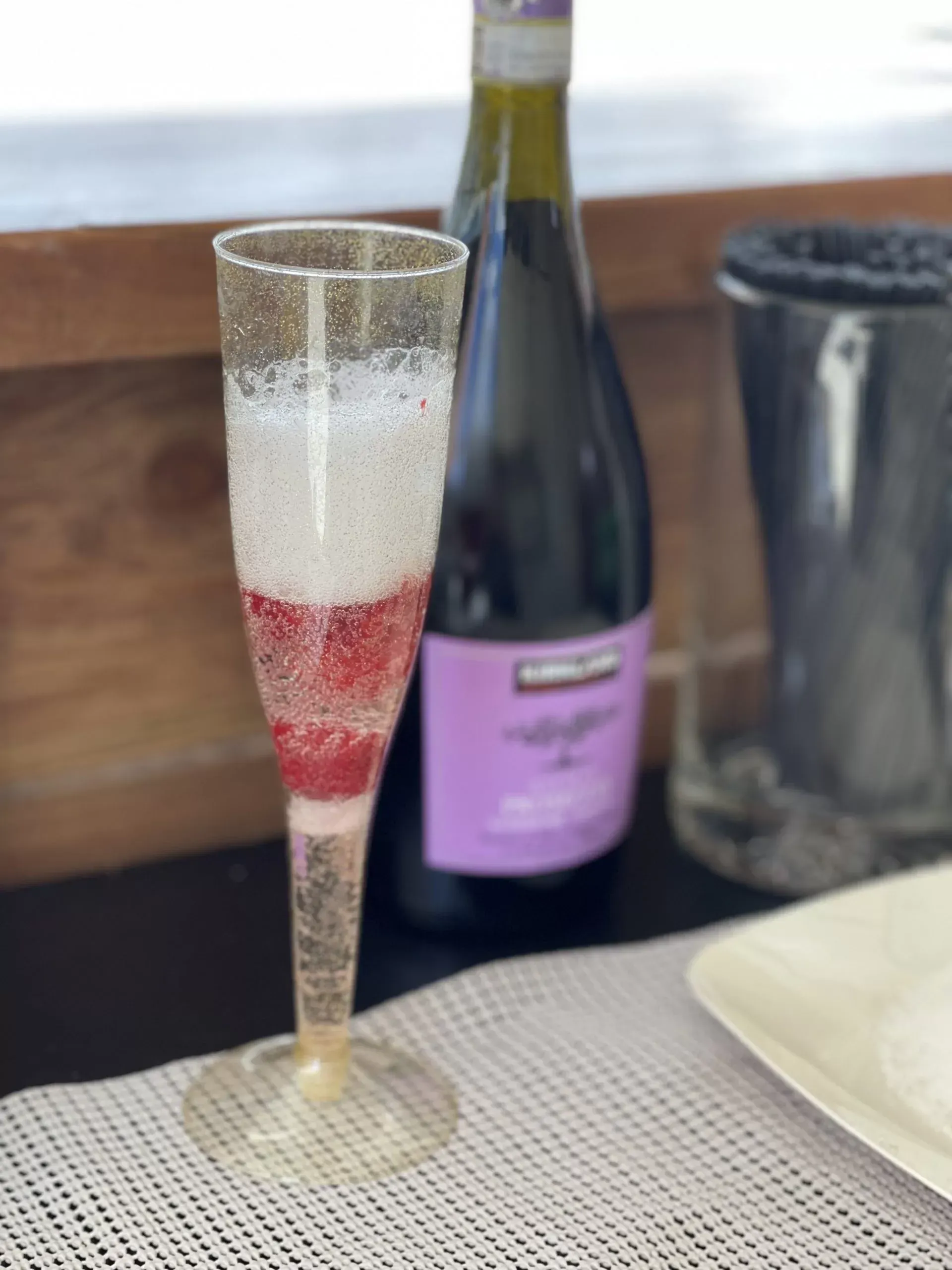 A bottle of wine and a glass of wine on a table