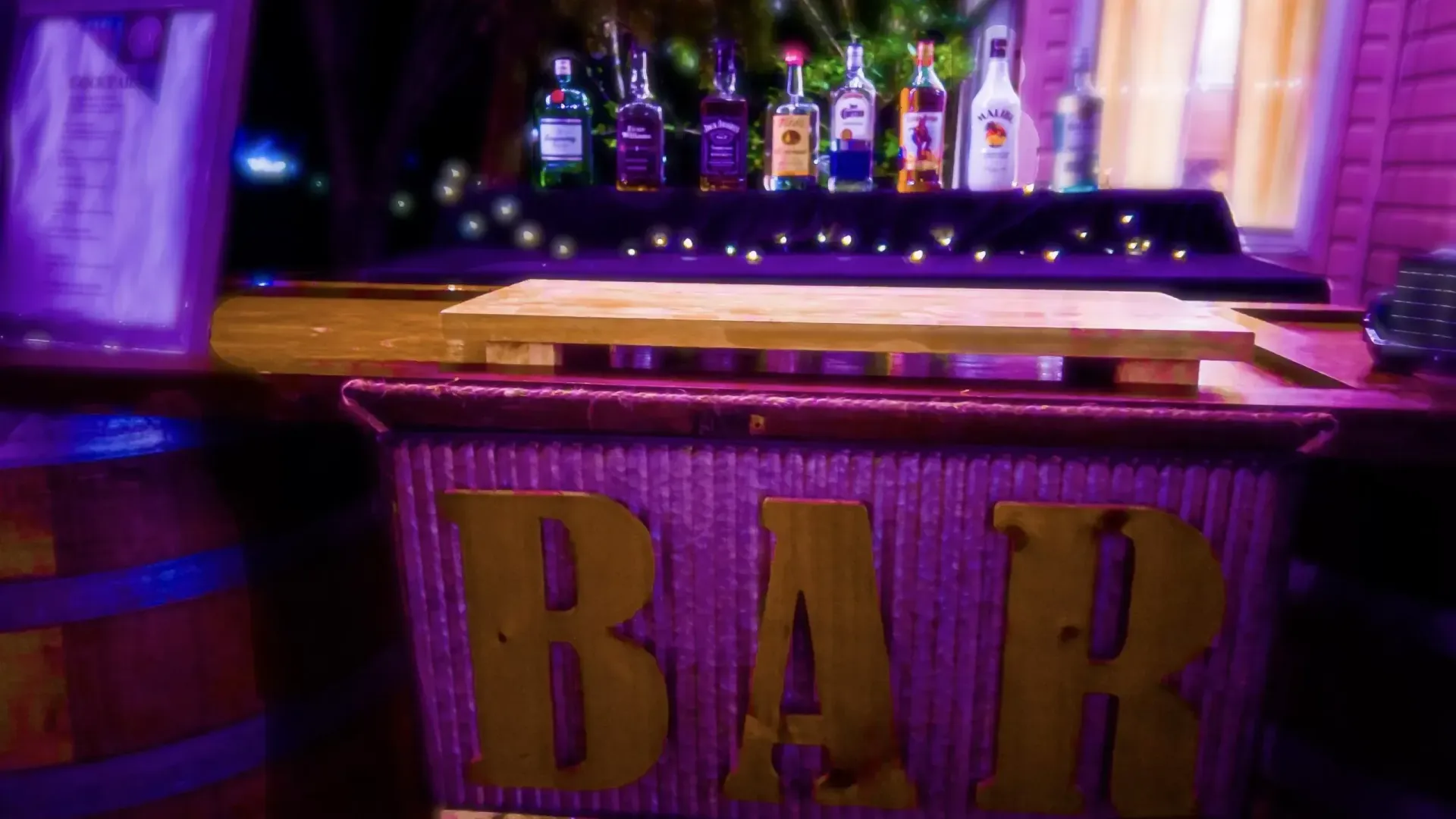 A bar with a lot of bottles of alcohol on it.
