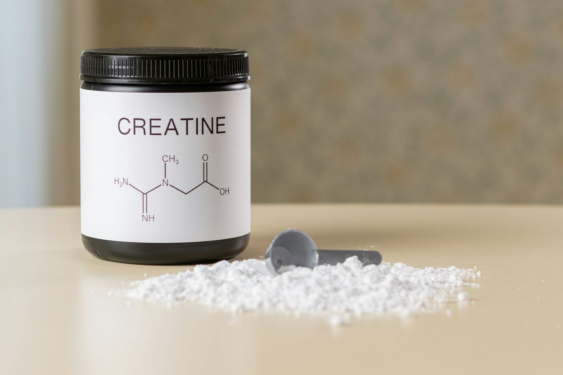 Pot of creatine powder with scoop