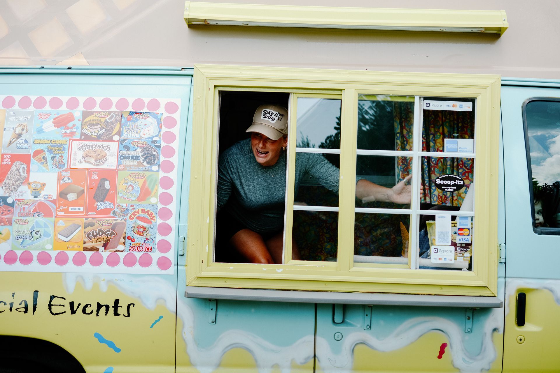 Person leaning out of ice cream truck window.