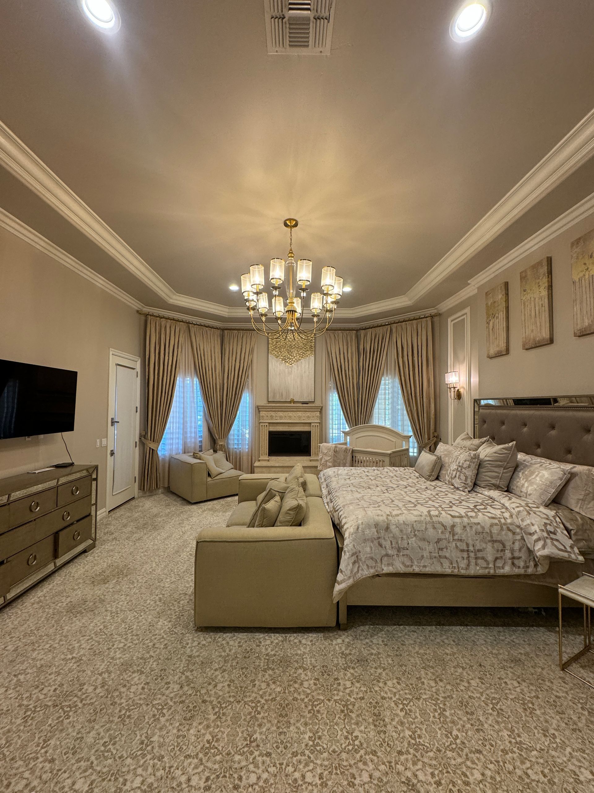 Bay window with beige walls, brown patterned curtains, and a tan carpet.