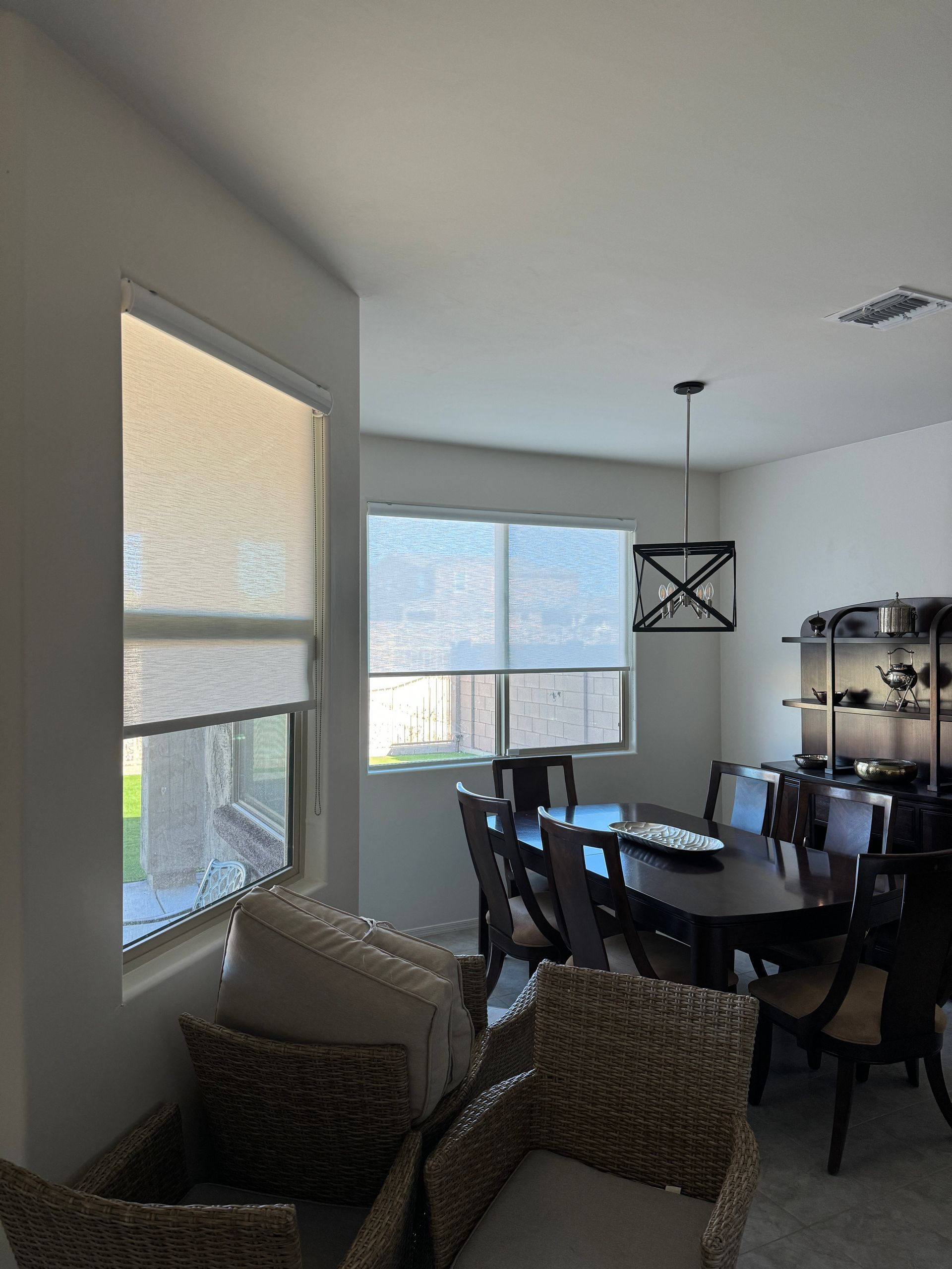 A dining room with wicker chairs and a table