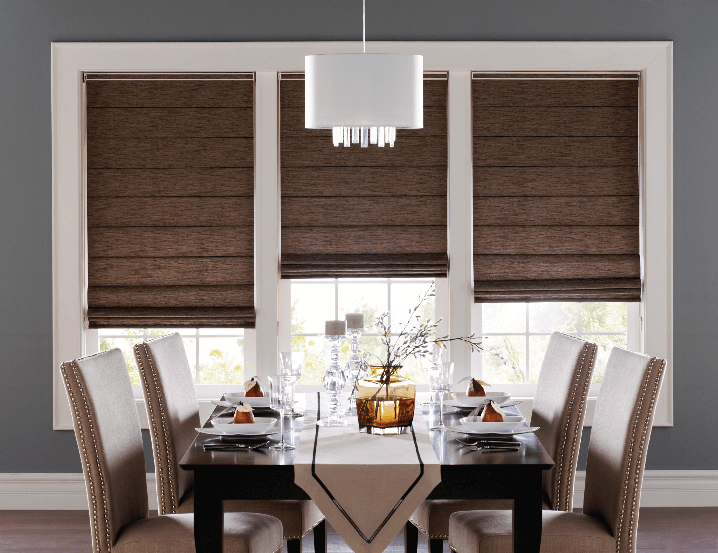 A dining room with a table and chairs with roman blinds