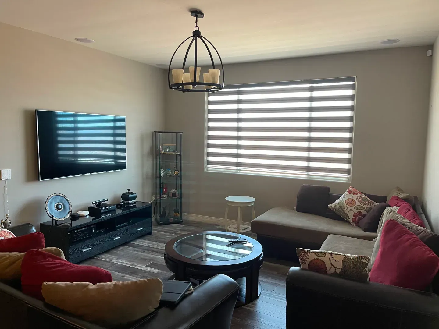 zebra blinds on a window of a living room with couches and chairs