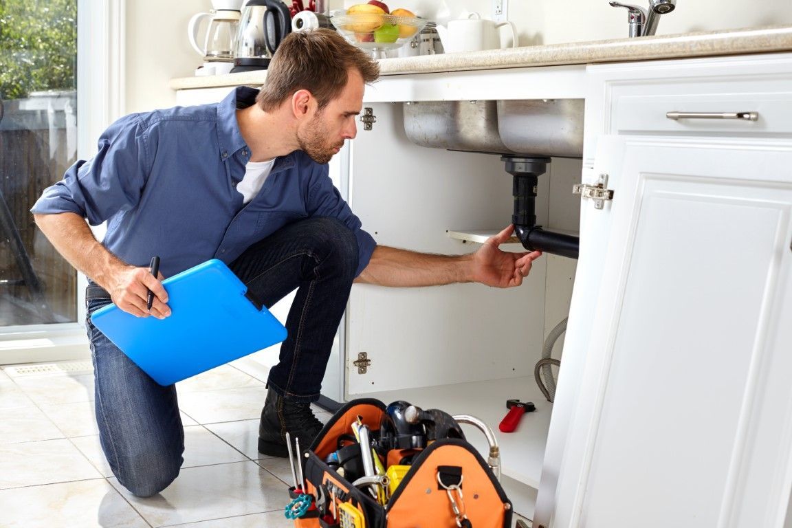 Collection of plumbing hardware and adjustable wrenches on a white background.