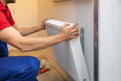 Man Installing House Heater — Cairo, GA — Parker’s Heating & Cooling, Inc.