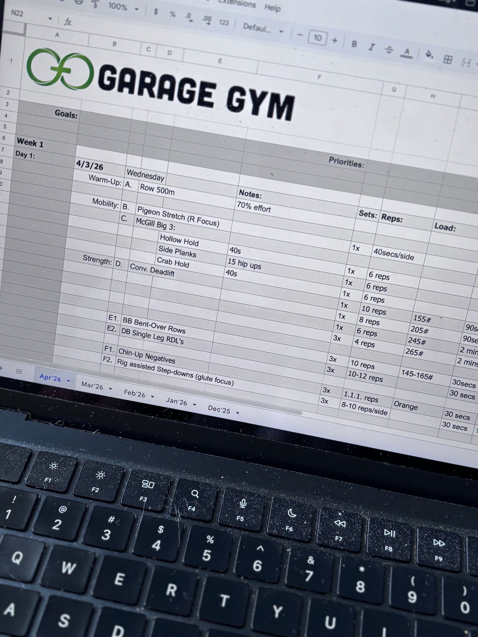 Laptop screen showing a Garage Gym spreadsheet with the keyboard in the foreground