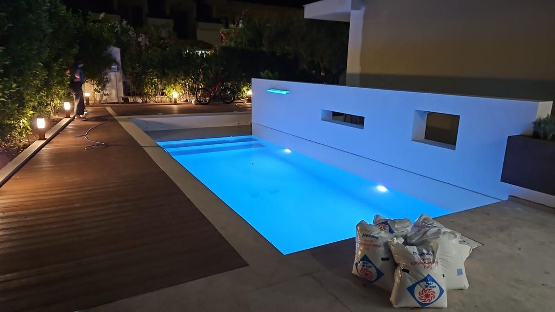 Moderno patio sul mare con vasca idromassaggio a sfioro turchese con vista sull'oceano.