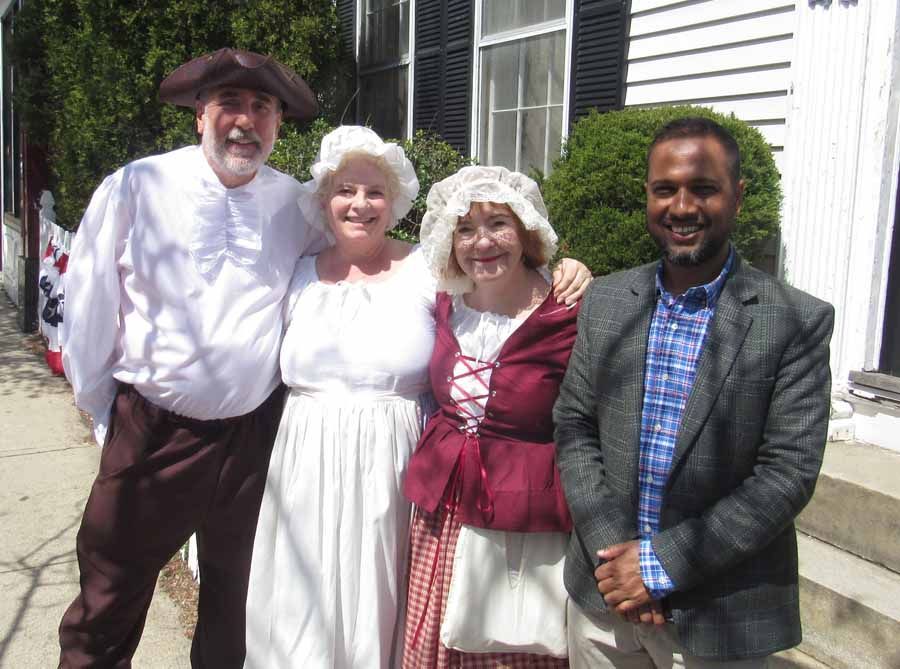 A group of people are posing for a picture in front of a house.