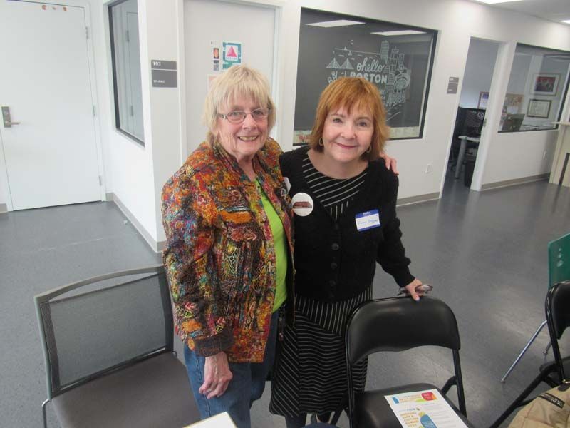 Two women are posing for a picture in a hallway.