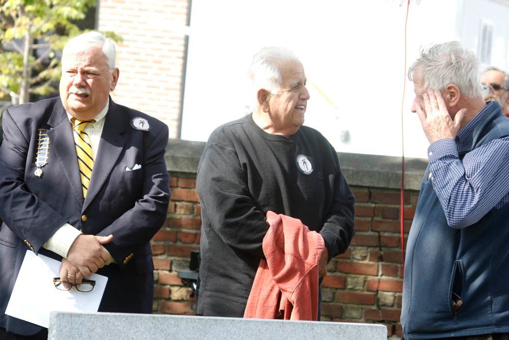 A group of men standing in front of a brick wall