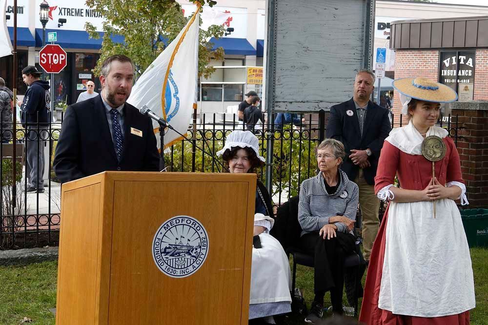 A man stands at a podium with a stop sign in the background