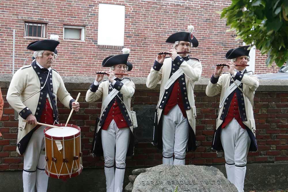 A group of men in military uniforms are playing instruments