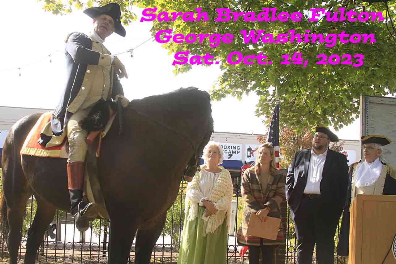 A man is riding a horse in front of a group of people