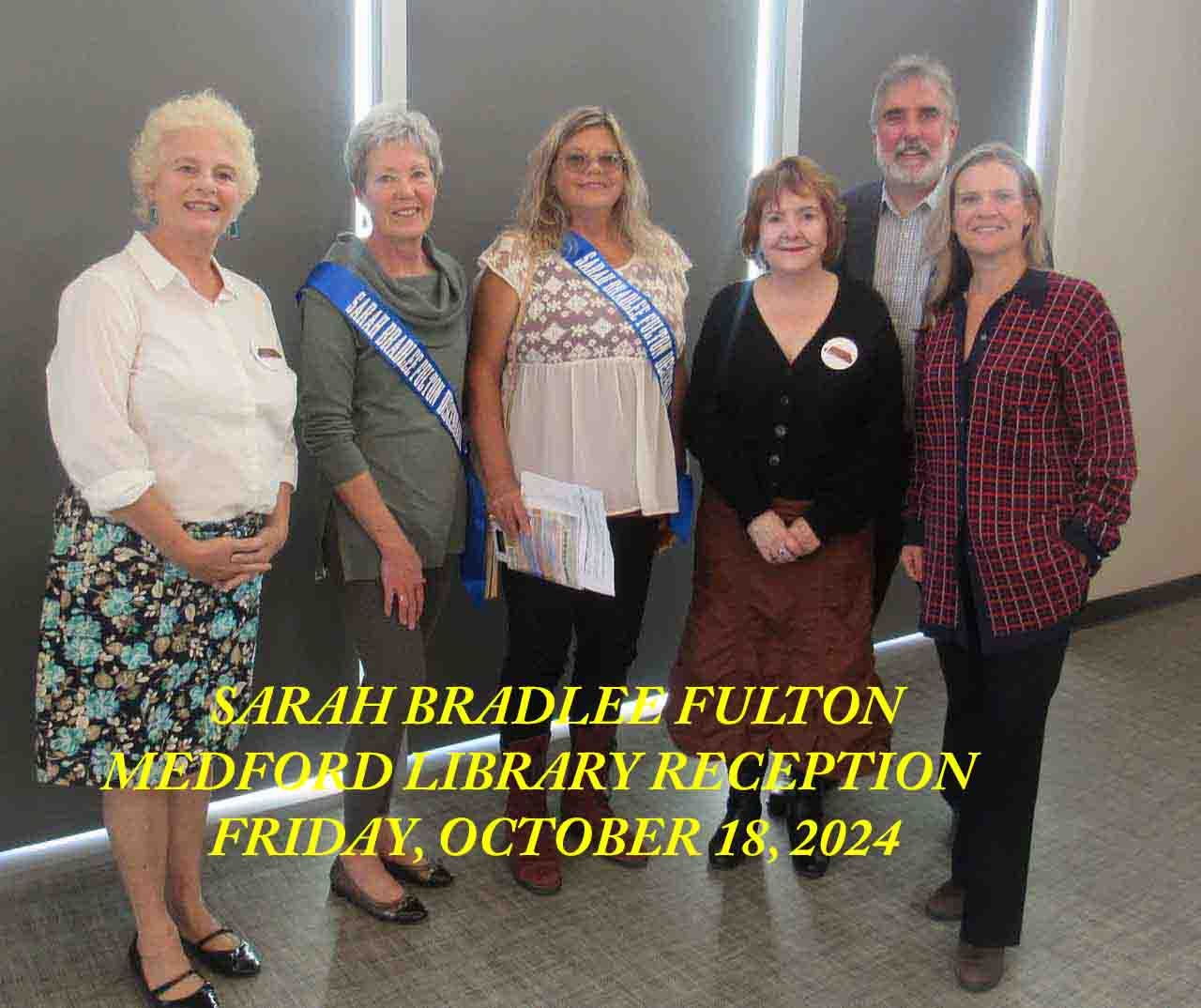A group of women are posing for a photo at the medford library reception
