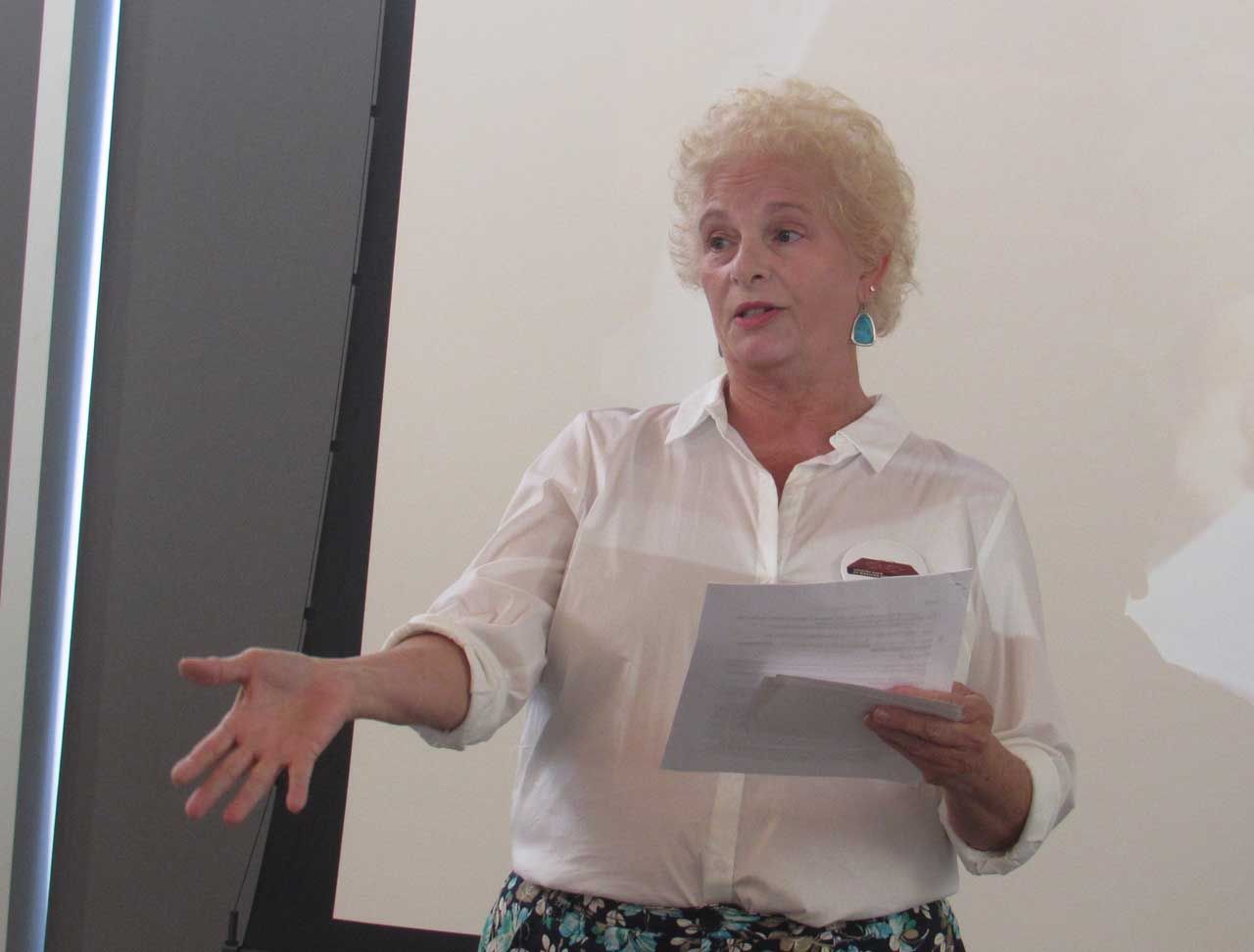 A woman in a white shirt is holding a piece of paper
