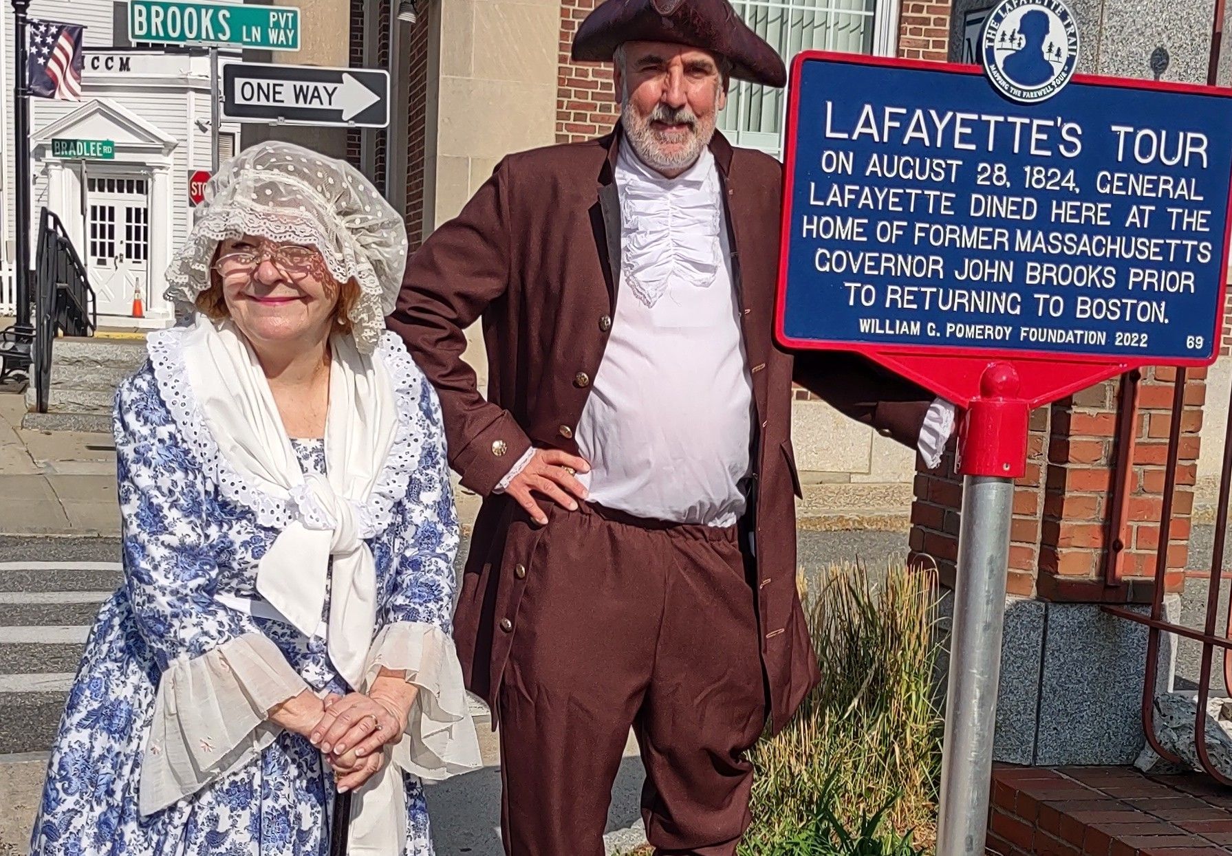 A man and woman standing next to a sign that says lafayette 's toy