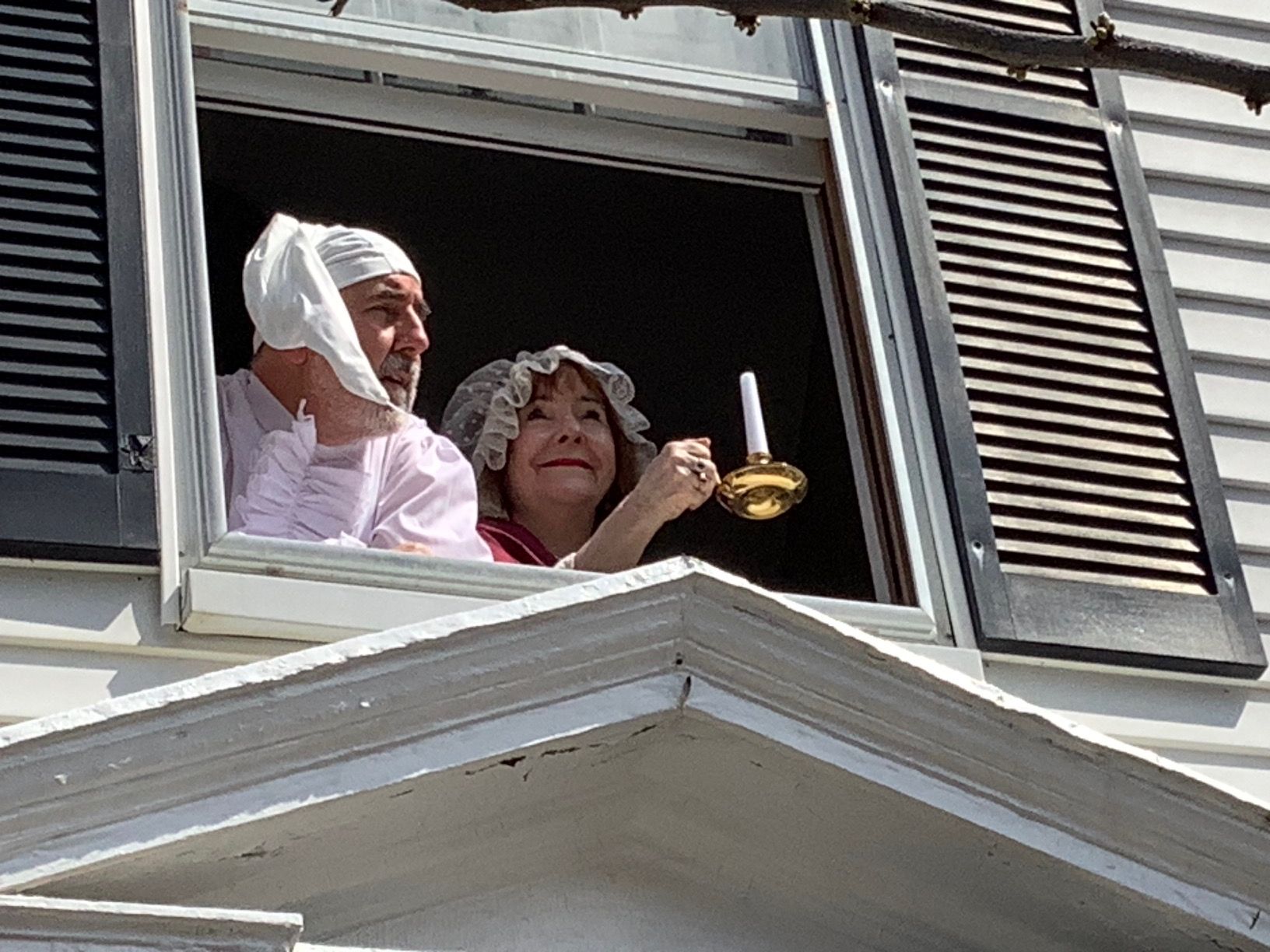 A man and a woman are looking out of a window
