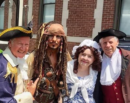 A group of people dressed in pirate costumes are posing for a picture.