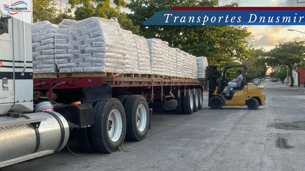 Un camión con una carretilla elevadora acoplada transporta una gran carga de bolsas.