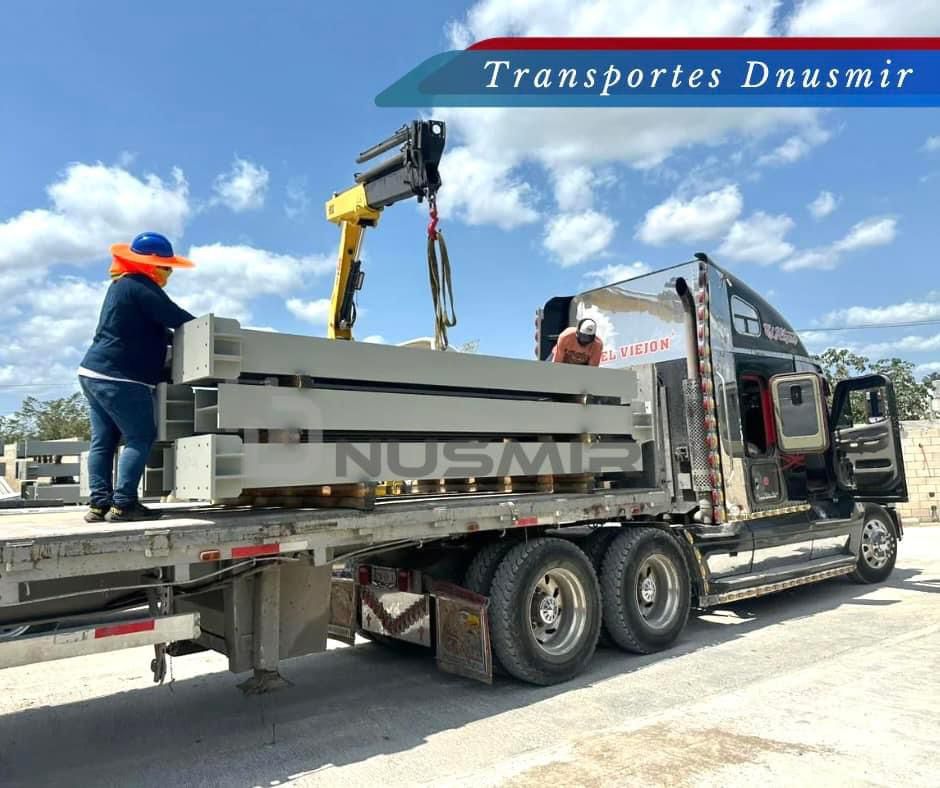 Un camión con una grúa en la parte trasera está siendo cargado con bloques de hormigón.