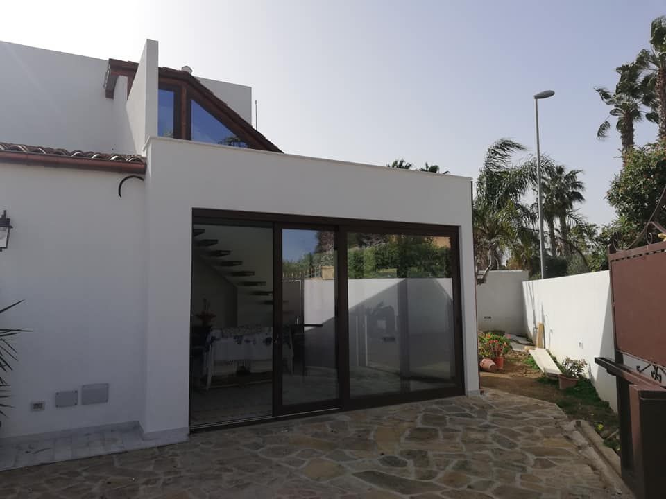 Una casa bianca con una grande porta scorrevole in vetro