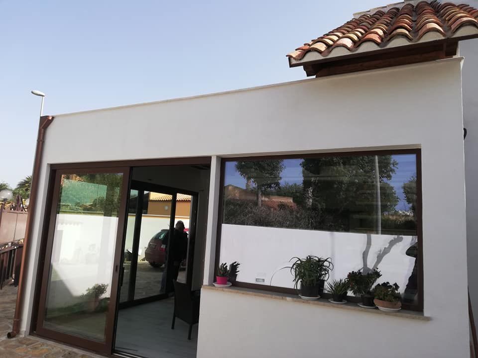 Un edificio bianco con tetto di tegole e una porta scorrevole in vetro