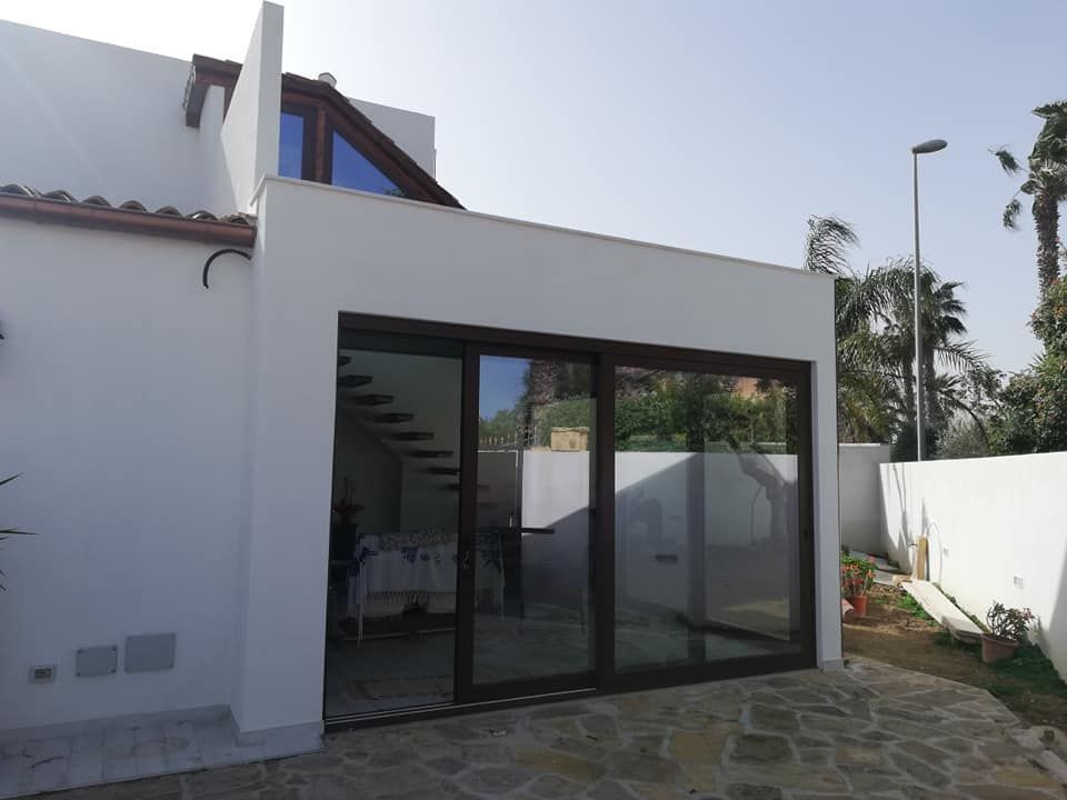 Una casa bianca con una grande porta scorrevole in vetro