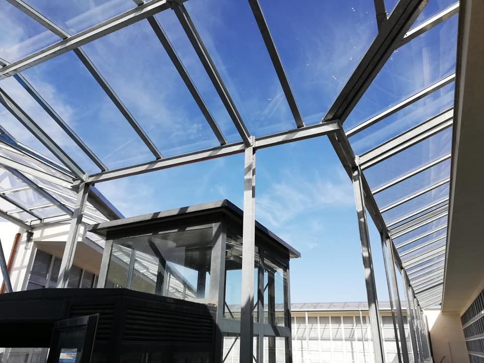 Un edificio con un tetto di vetro e un cielo azzurro sullo sfondo