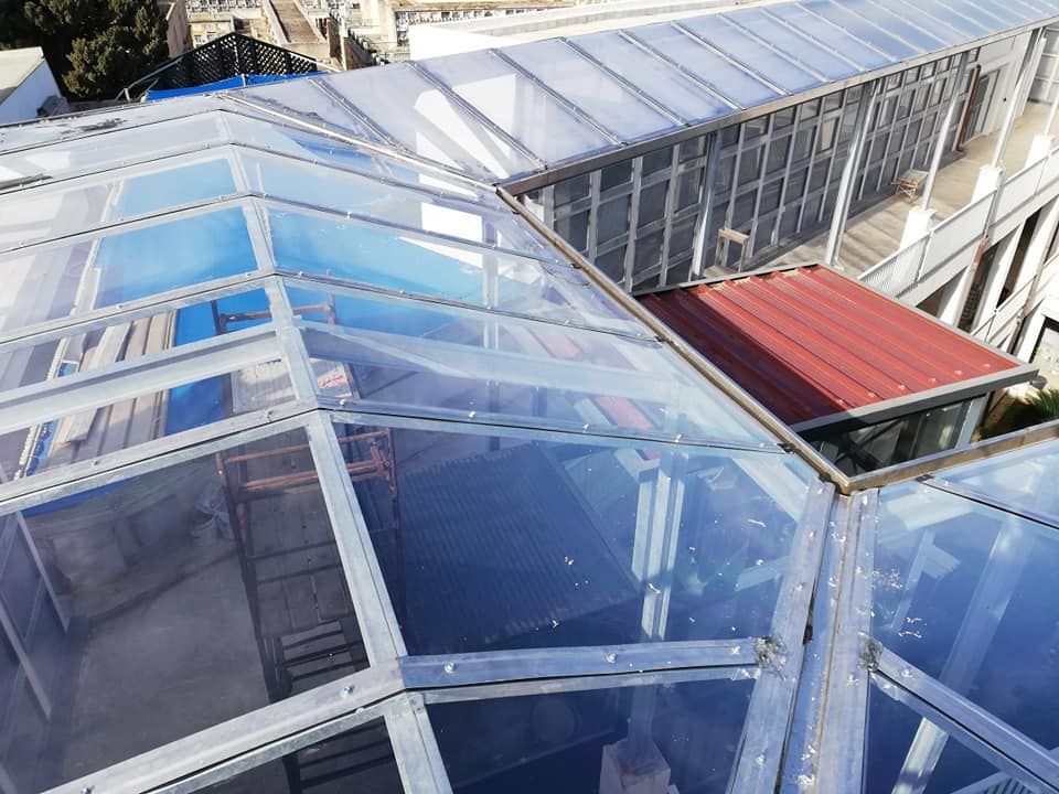 Un edificio con un tetto trasparente e un tetto rosso