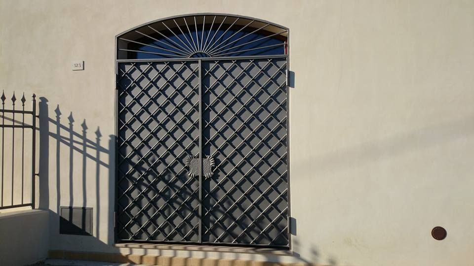 Un cancello in ferro battuto è sul lato di un edificio