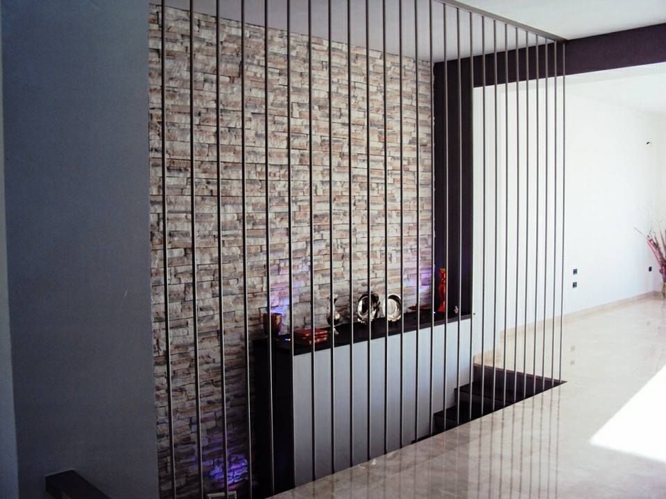 Una stanza con un muro di mattoni e una ringhiera in acciaio inossidabile