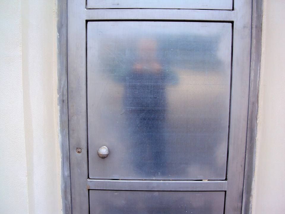 Una porta in acciaio inossidabile con il riflesso di una persona al suo interno