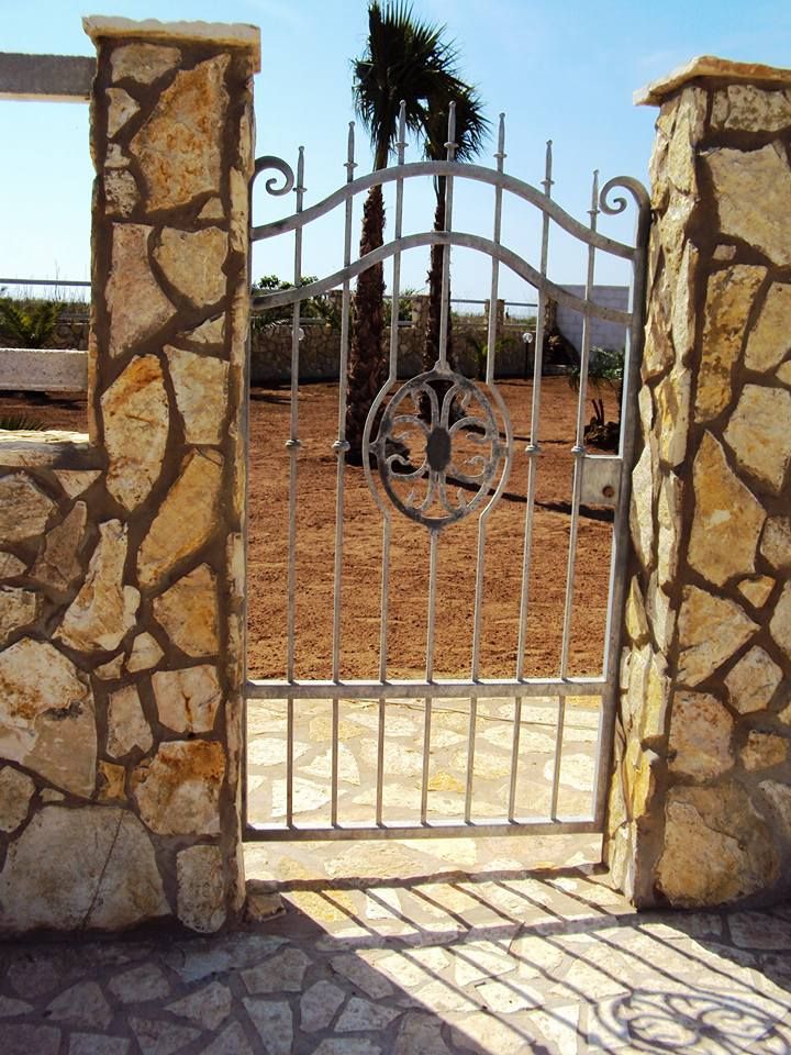 Un muro di pietra con un cancello di metallo di fronte