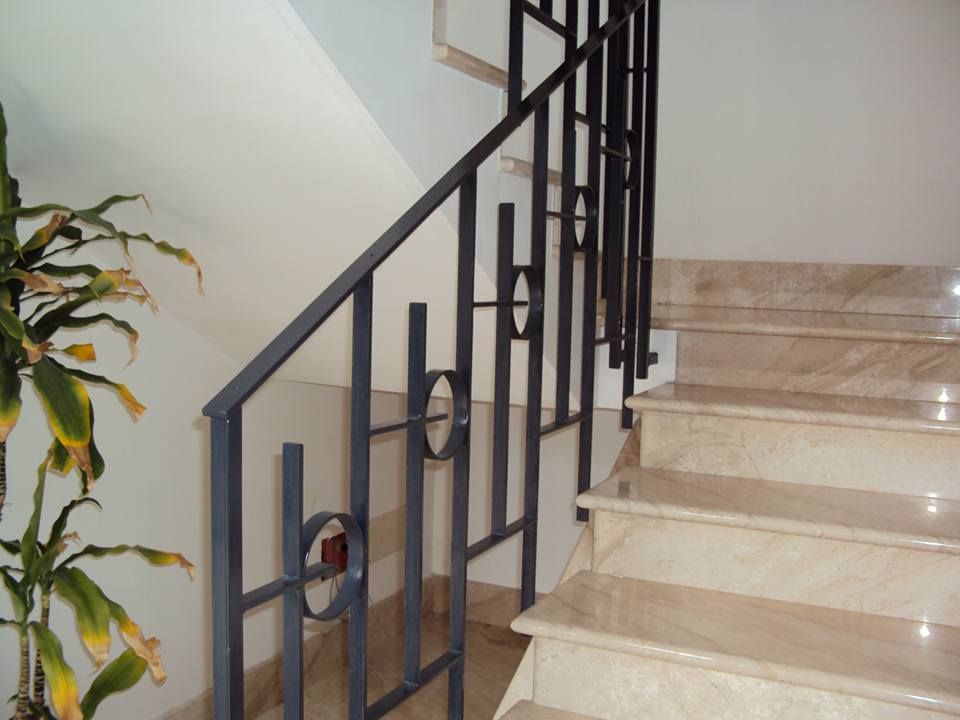 Una scala con ringhiera in metallo e gradini in marmo