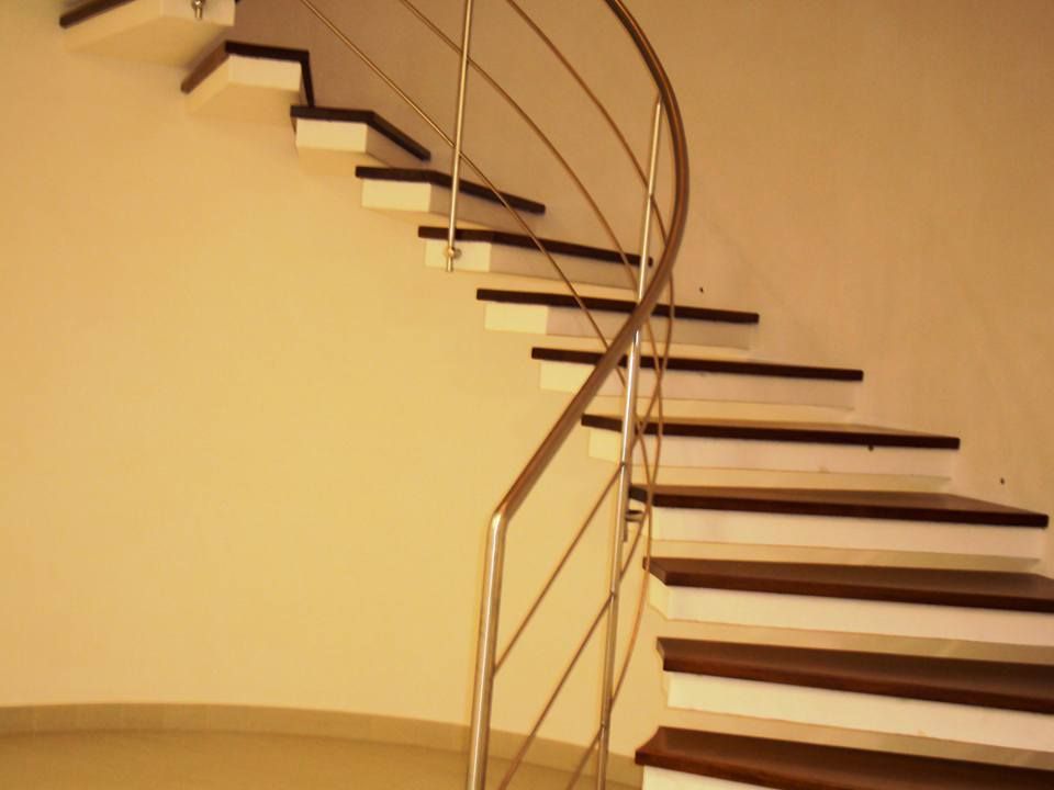 Una scala a chiocciola con gradini in legno e ringhiera in metallo