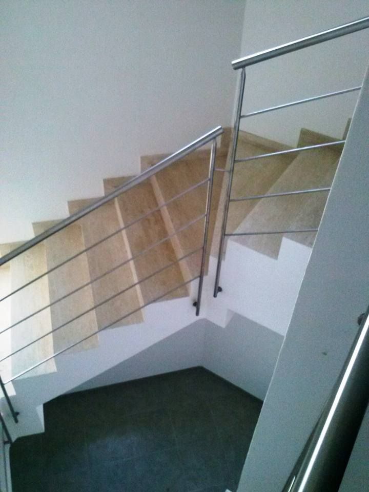 Una scala con ringhiera in metallo e gradini in legno