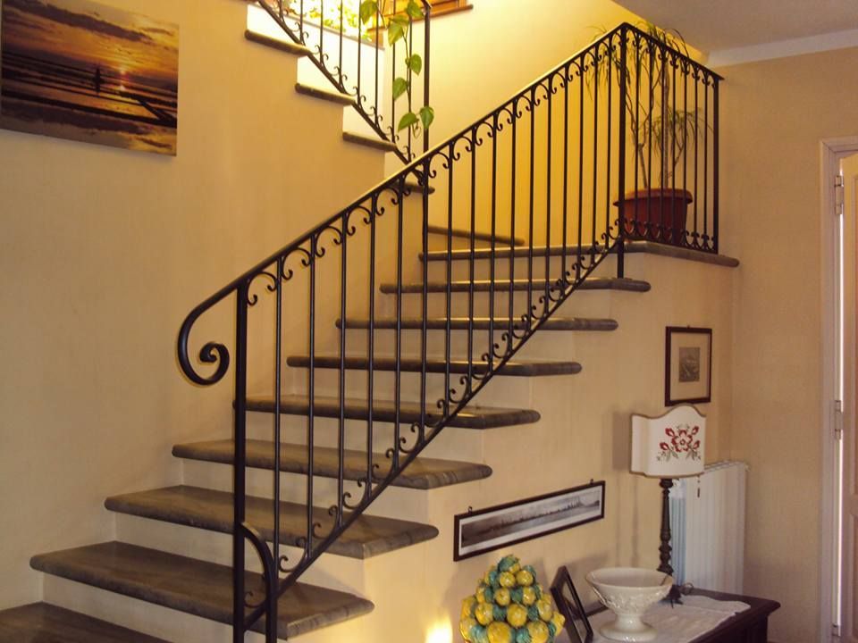 Una scala con ringhiera in ferro battuto in una stanza