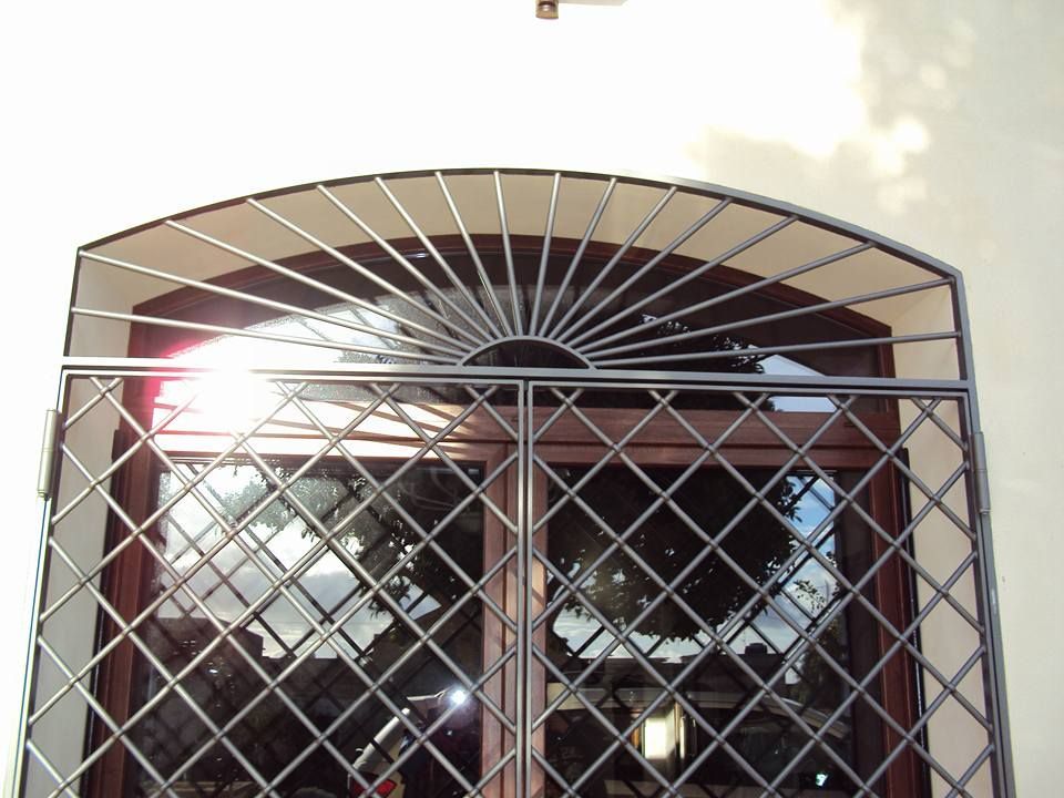 Una finestra con una grata in ferro battuto