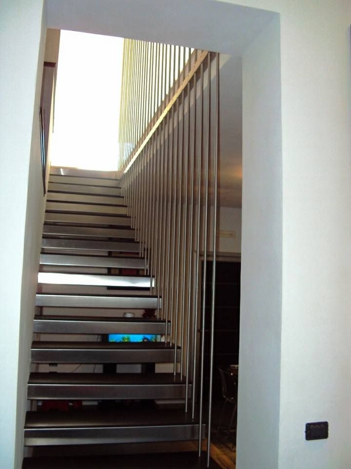 Una scala con ringhiera in acciaio inossidabile che conduce al secondo piano